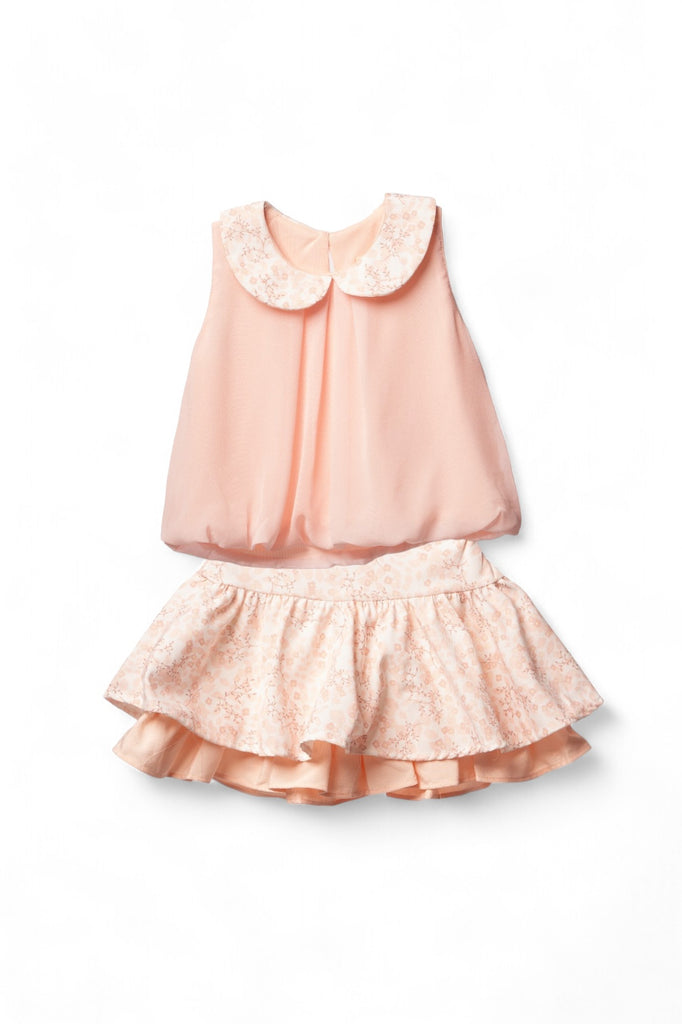Stylish girl’s outfit featuring a sleeveless salmon top with a floral collar and a matching floral skirt with ruffled hem