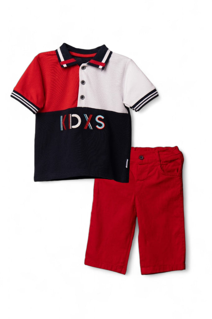 A stylish boy's casual outfit consisting of a red polo shirt with black and white panels, paired with red shorts.