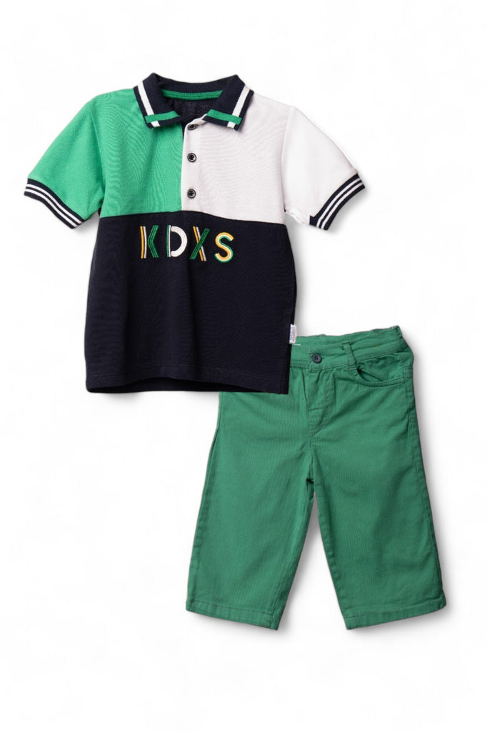 A stylish boy's casual outfit consisting of a green polo shirt with black and white panels, paired with green shorts.